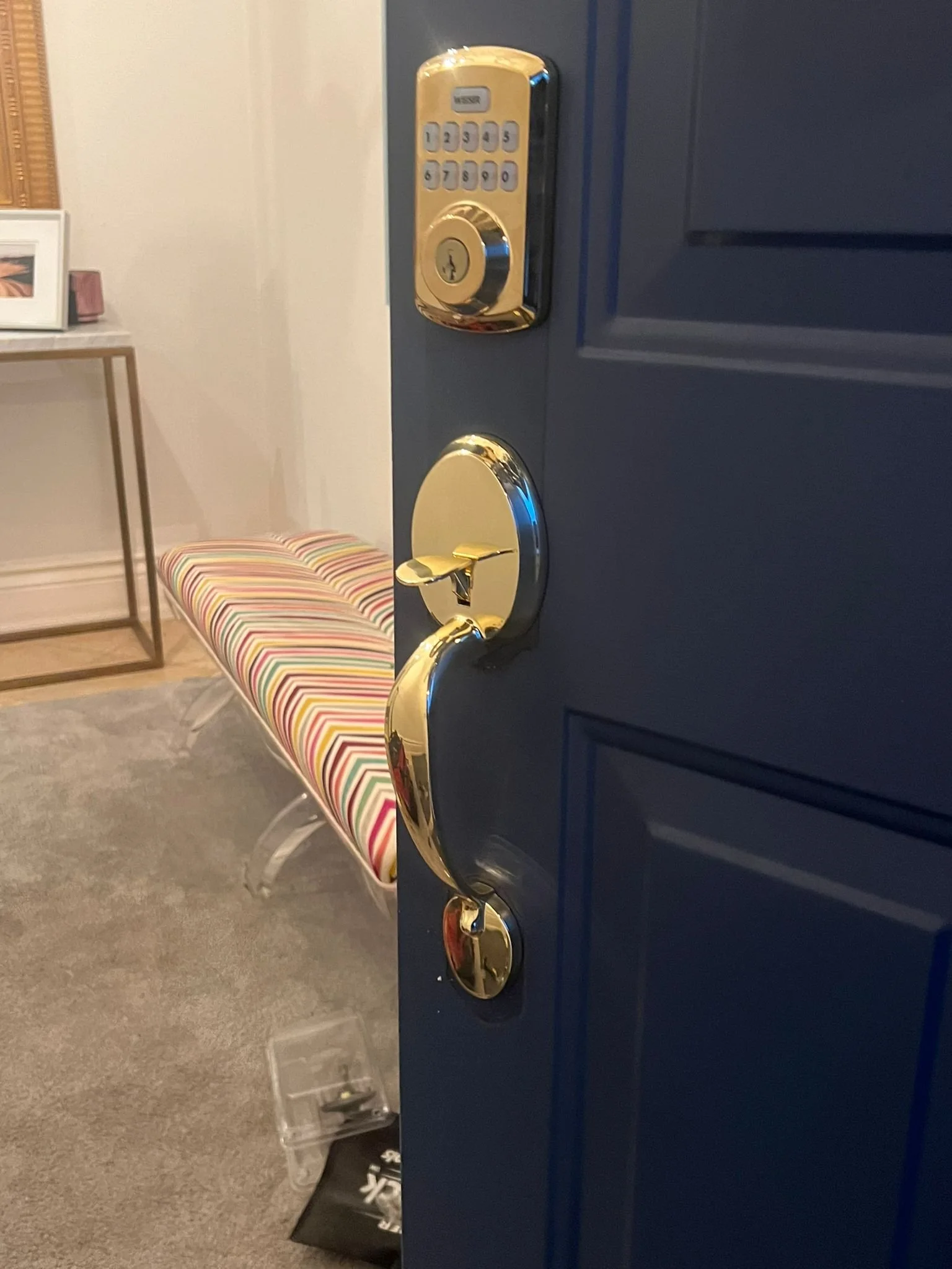 Gold keypad deadbolt and handle on a navy entry door