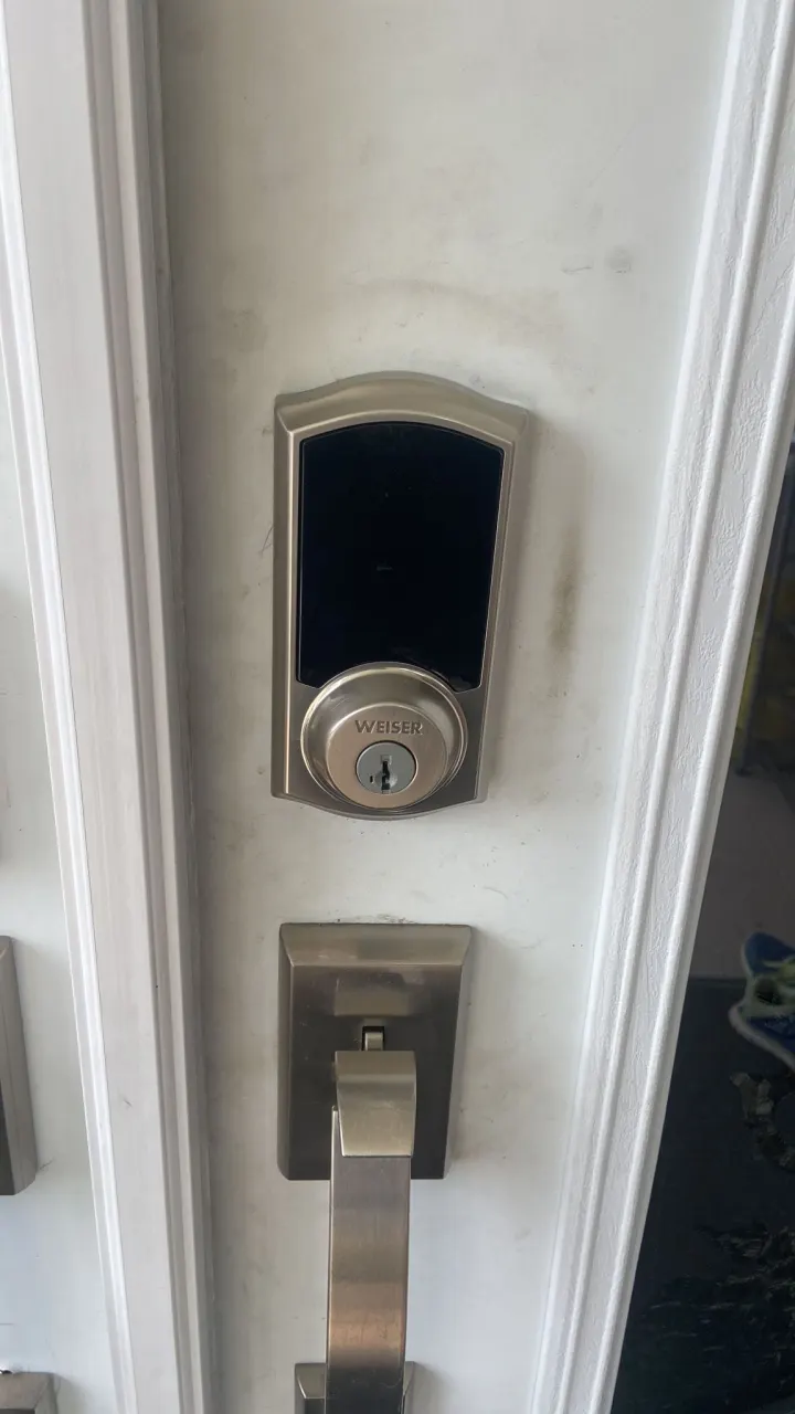 Weiser smart deadbolt installed above a square door handle
